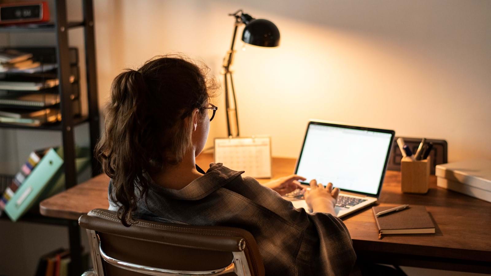 Woman sitting at desk watching webinar on creating an enterprise intranet