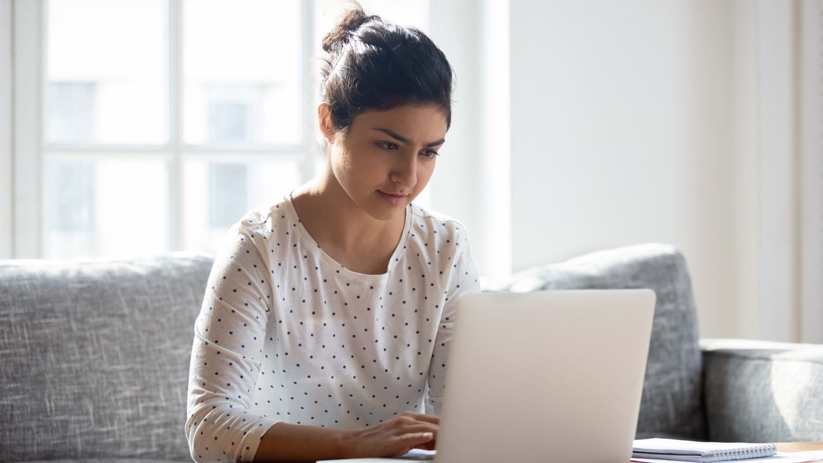 Happy female employee using a digital workplace on a laptop