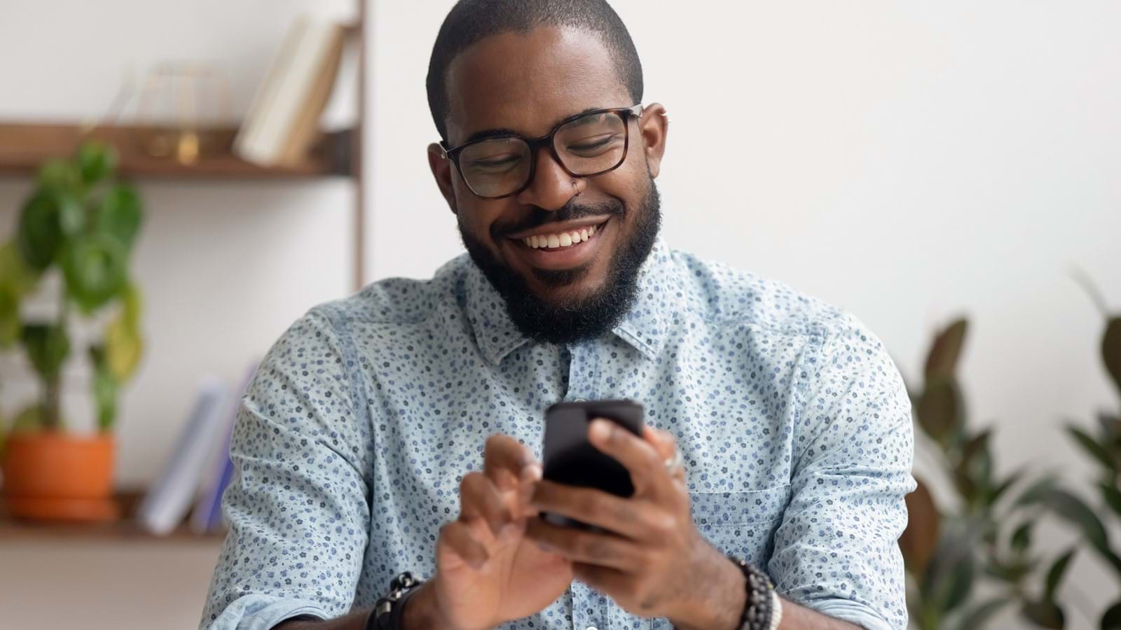 Employee using his mobile to reach his company's digital workplace, smiling and having a good experience