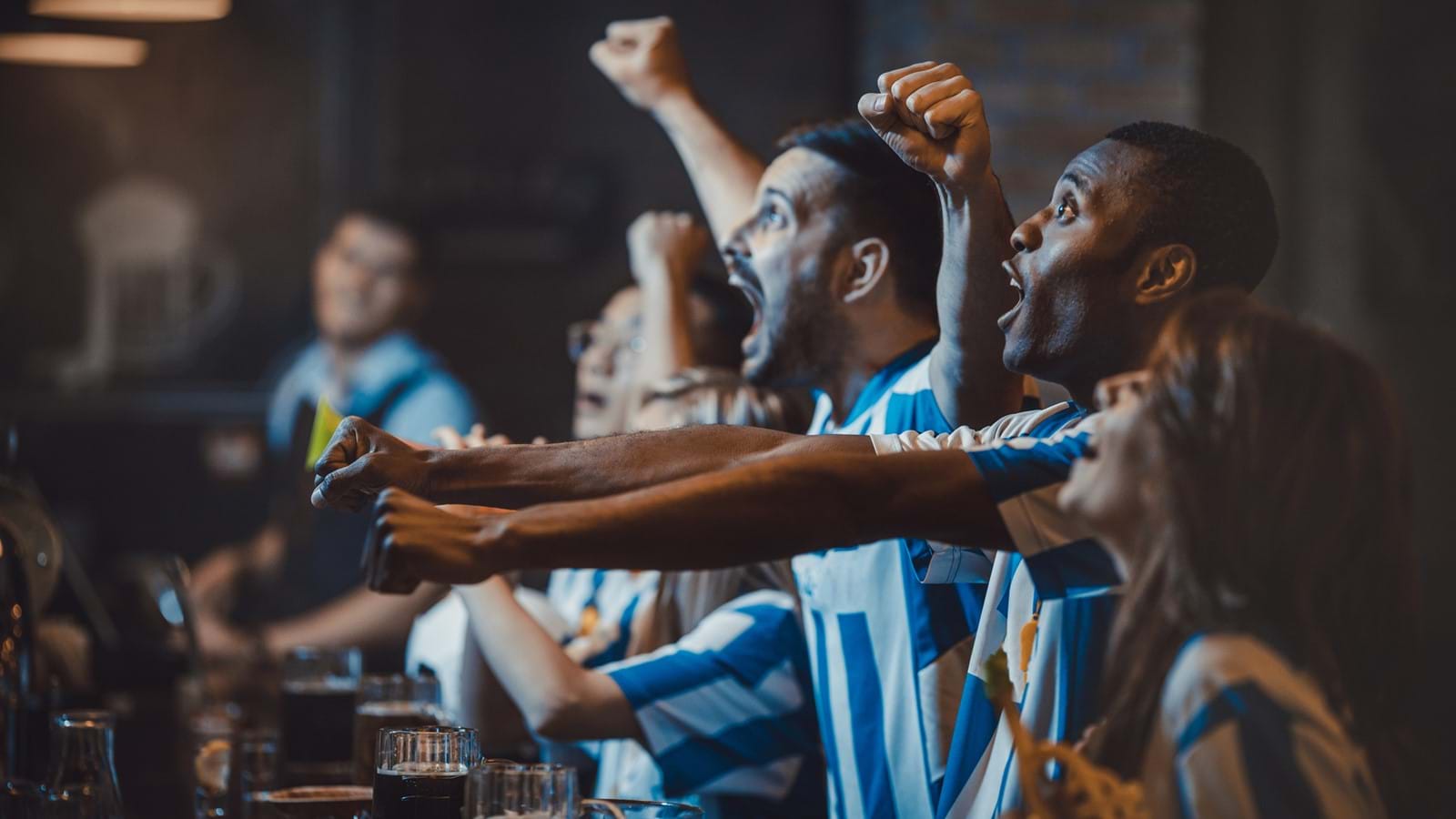 Football fans cheering in a bar
