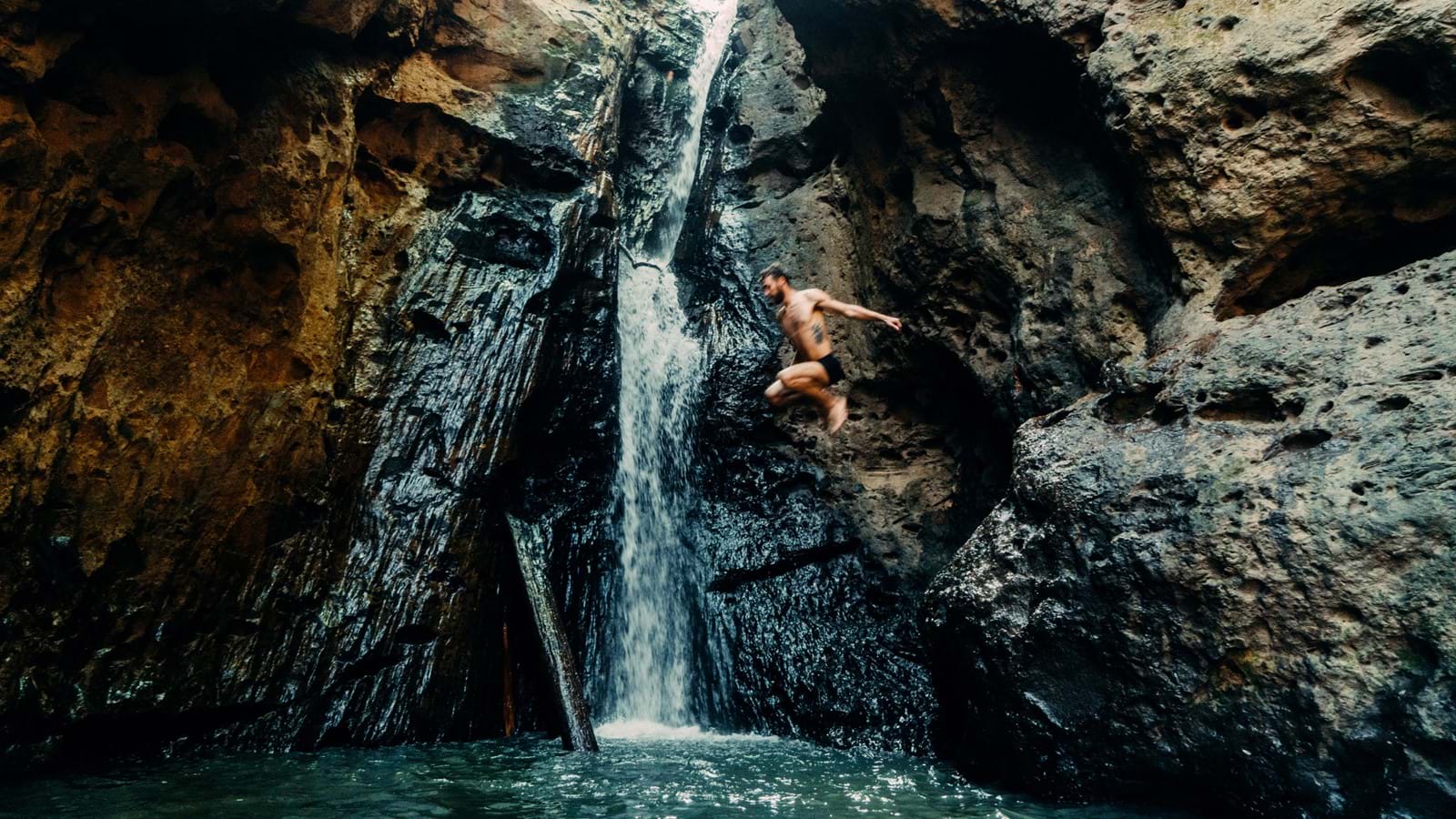 Man jumping from waterfall