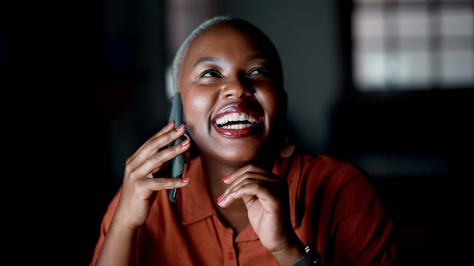 Employee smiling, calling a colleague on her phone